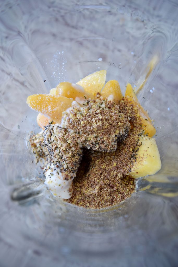 Bananas, pineapple, peaches, seeds in a blender, prior to mixing