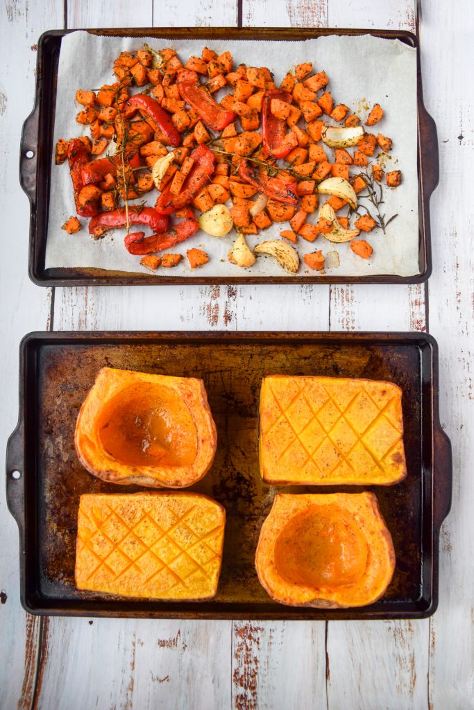 2 trays, one with a roasted butternut squash and the other with other roasted veggies