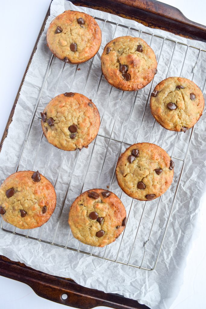 cookie sheet with parchment paper, covered with 7 banana chocolate chip muffins