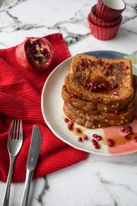 plate of gingerbread french toast topped with pomegranate