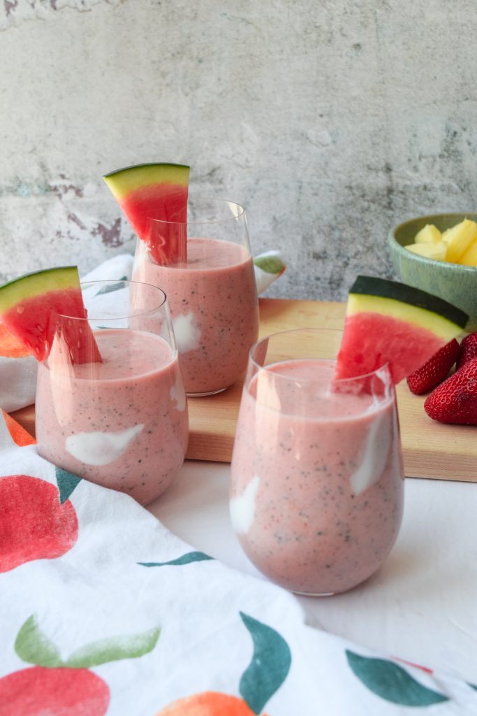 3 watermelon and fruit smoothies topped with a slice of watermelon