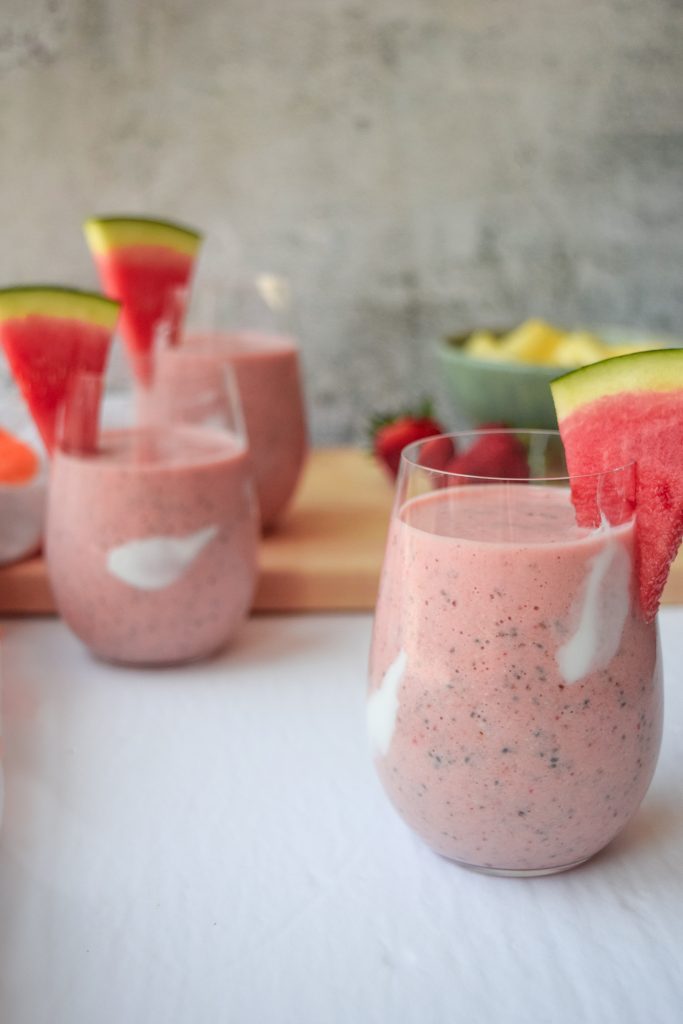 3 watermelon and fruit smoothies topped with a slice of watermelon