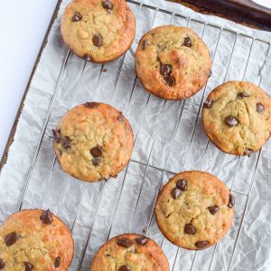 cookie sheet with parchment paper, covered with 7 banana chocolate chip muffins