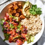 close up shot on a tofu bowl with citrus salad, avocado and brown rice